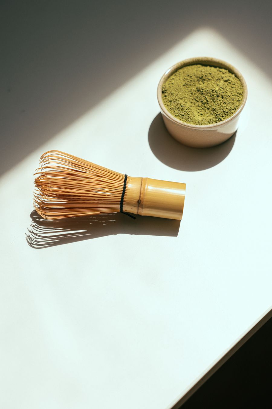 Matcha powder and a bamboo whisk