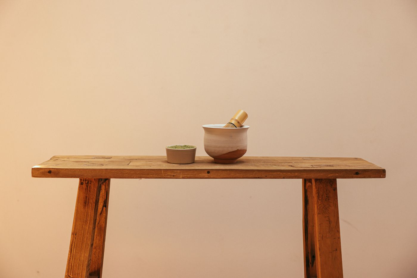 A matcha bowl and whisk resting on a table