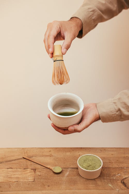Person Holding White Ceramic Cup With Green Tea