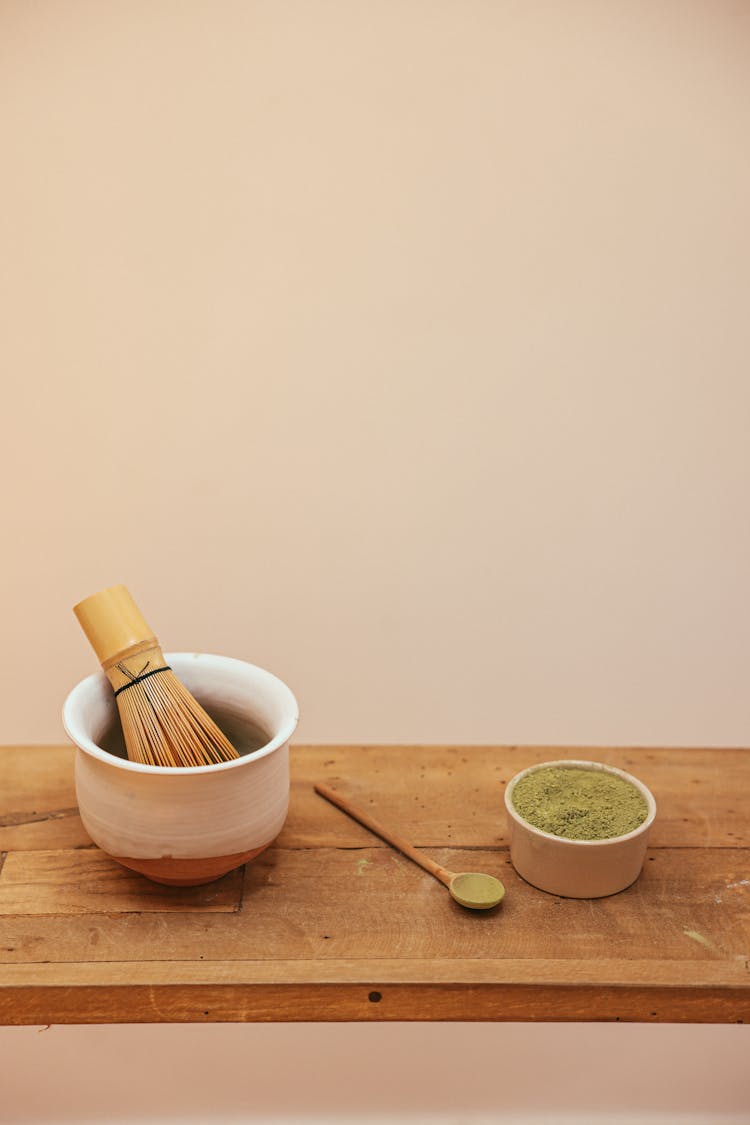 Bamboo Whisk On A Bowl Beside A Bowl Of Ceremonial Grade Matcha