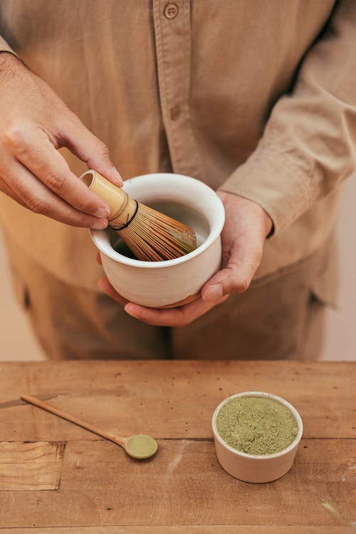 Person Holding a Bamboo Whisk