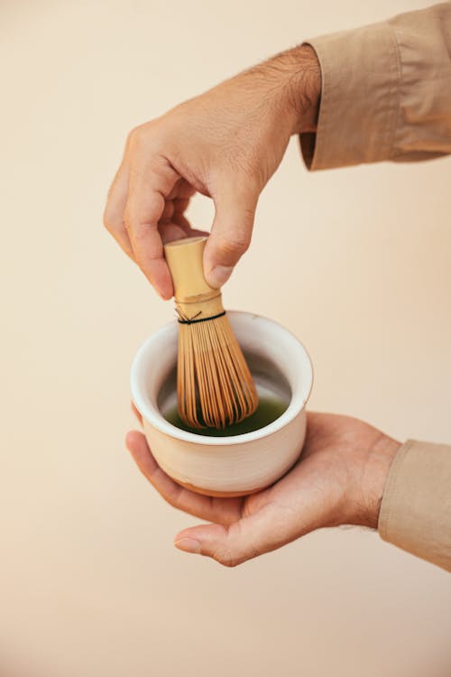 Free A Person Holding a Bamboo Whisk Stock Photo
