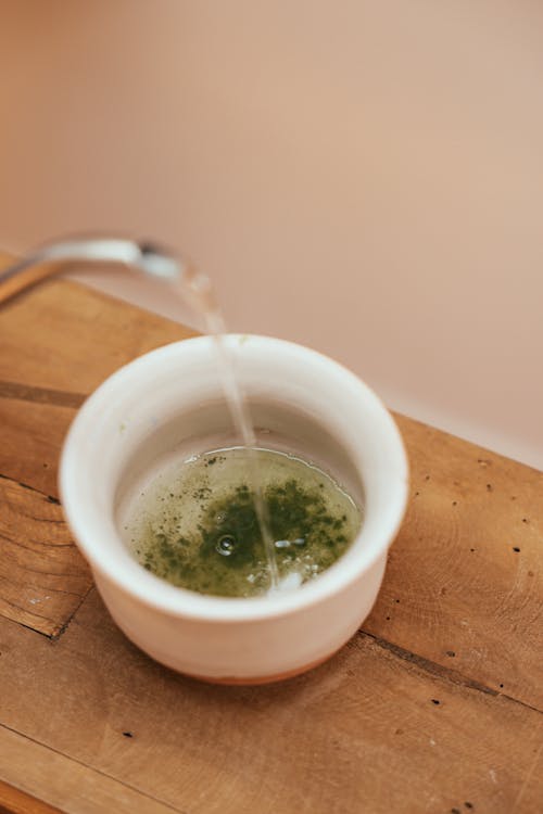Free Pouring Water in a Bowl with Matcha Powder Stock Photo