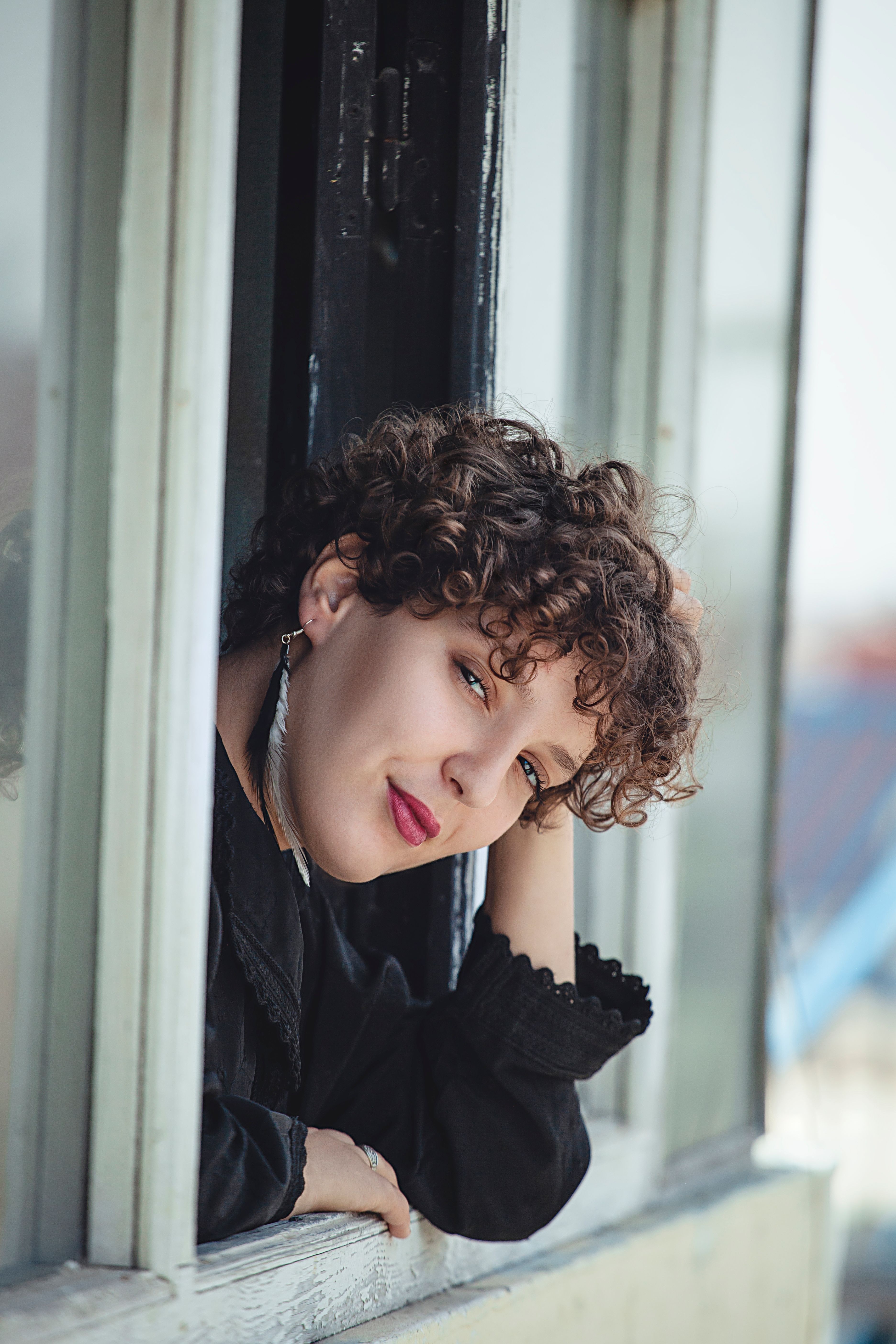 A Woman in Black Long Sleeves Looking Outside the Window · Free Stock Photo