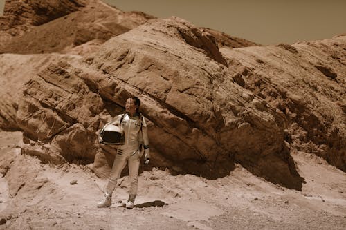 Free A Woman Wearing a Space Suit Holding a Helmet Stock Photo