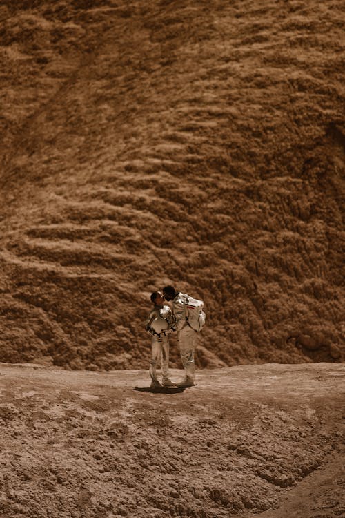 Astronauts in Spacesuits Kissing Each Other on a Mars Surface 