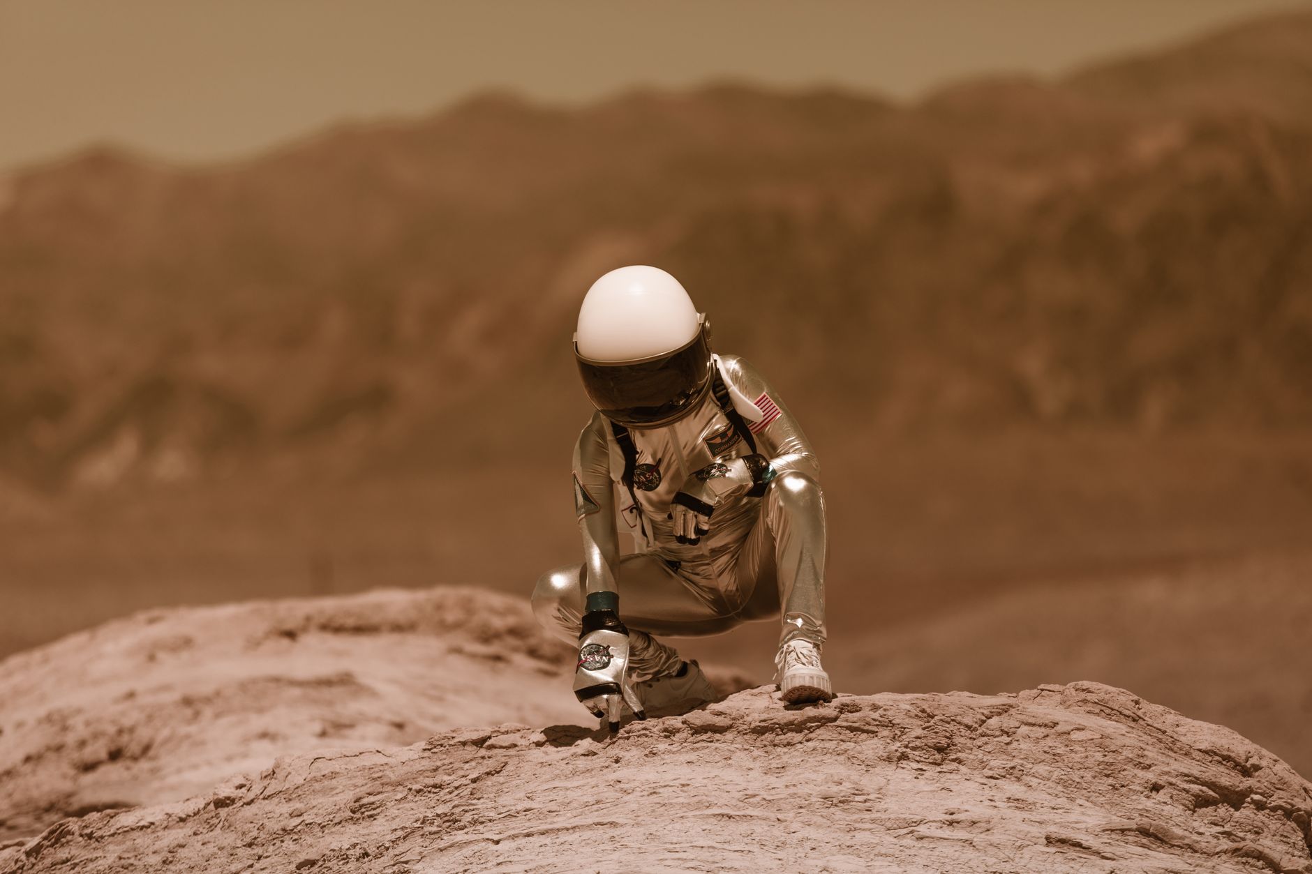 An astronaut in a spacesuit exploring a rocky landscape, evoking adventure and sci-fi themes.