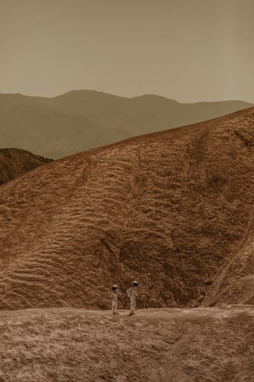 Free Two astronauts in space suits explore a barren, Mars-like landscape. Stock Photo