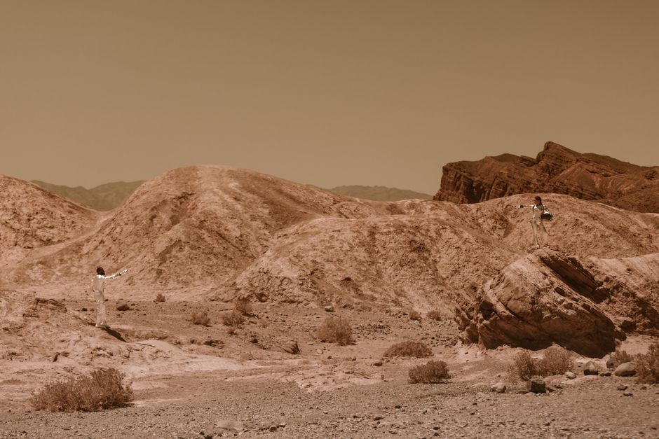 Two astronauts in a rocky desert landscape, evoking Mars exploration. Two astronauts in a rocky desert landscape, evoking Mars exploration.