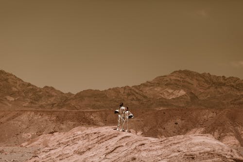 Man and a Woman in Space Suits Looking Afar 