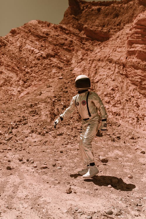 An Astronaut Walking on Dry Rocky Land