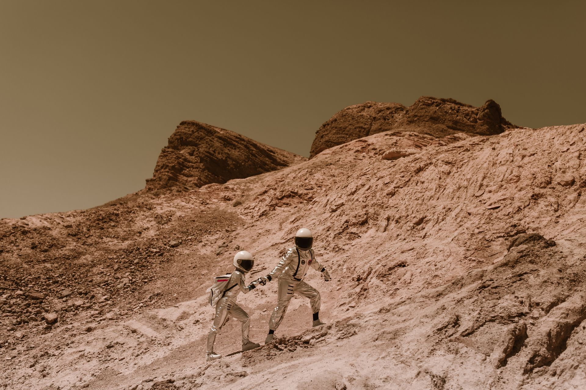 Astronauts Holding Hands and Walking up the Hill on Mars