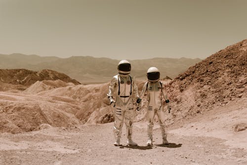 Astronauts in Spacesuits Standing and Holding Hands 