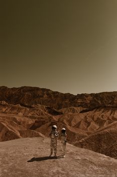 A couple dressed as astronauts explores a barren Mars-like landscape under a sepia-toned sky.