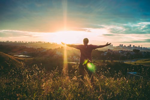 Free Person Spreading Hands Against Sun Stock Photo