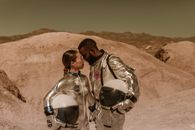 Man and Woman Kissing on Brown Rock Formation