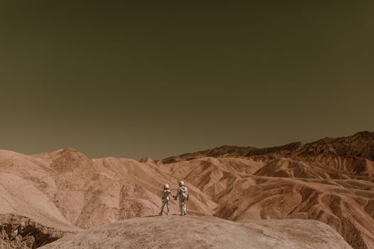 Astronauts holding hands, exploring a mars-like desert landscape under a clear sky.