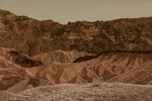 Free Astronauts exploring a stunning desert landscape, resembling Mars. Stock Photo