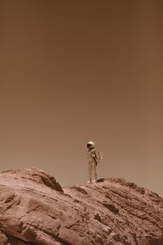 Astronaut in spacesuit standing on rocky desert-like terrain with a barren sky.