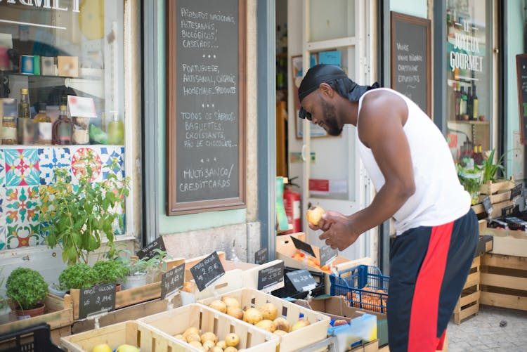 A Man Looking At Fruits Outside A Grocery Store