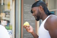 Man in White Tank Top Holding Yellow Fruit