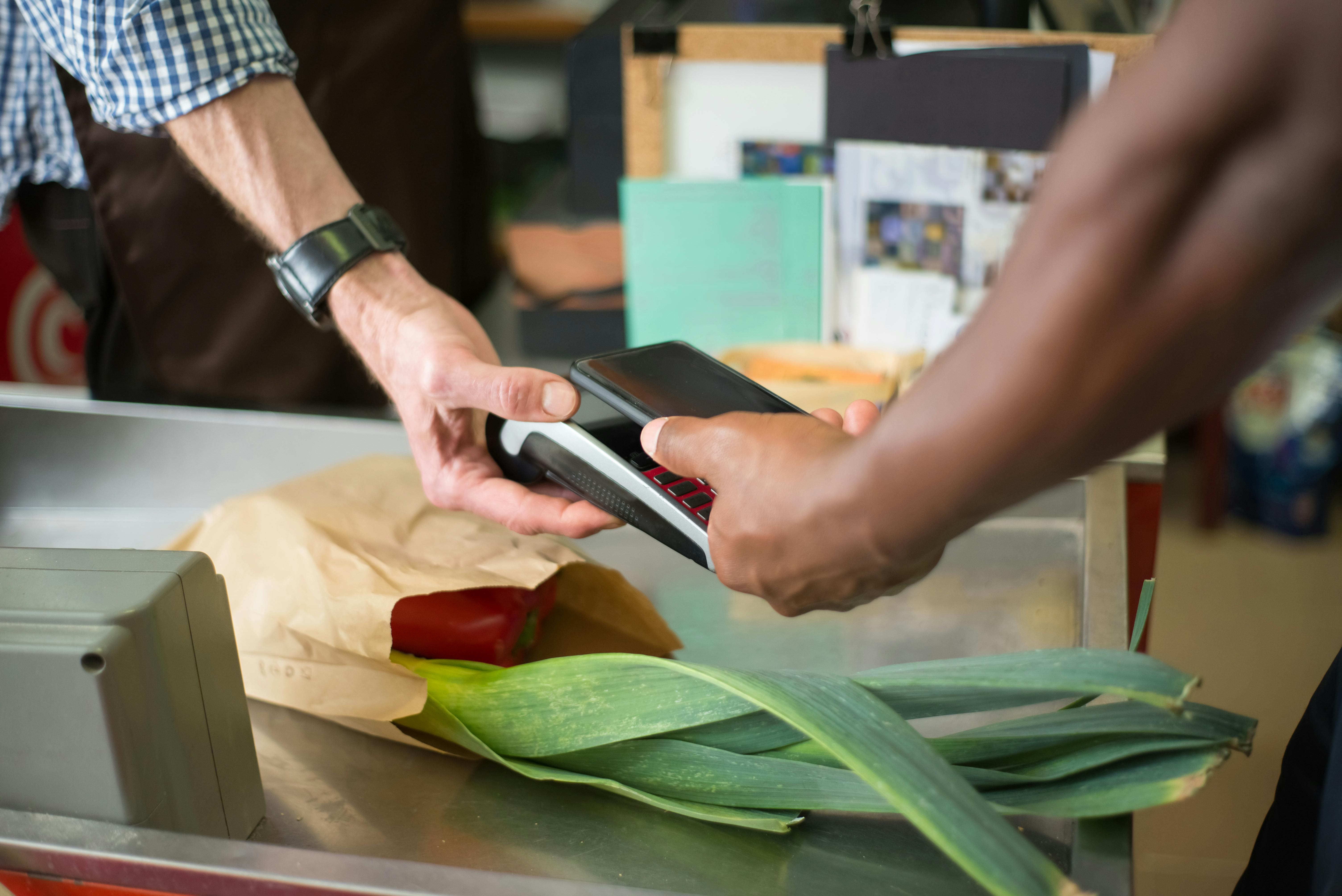 a customer paying for groceries using a smartphone