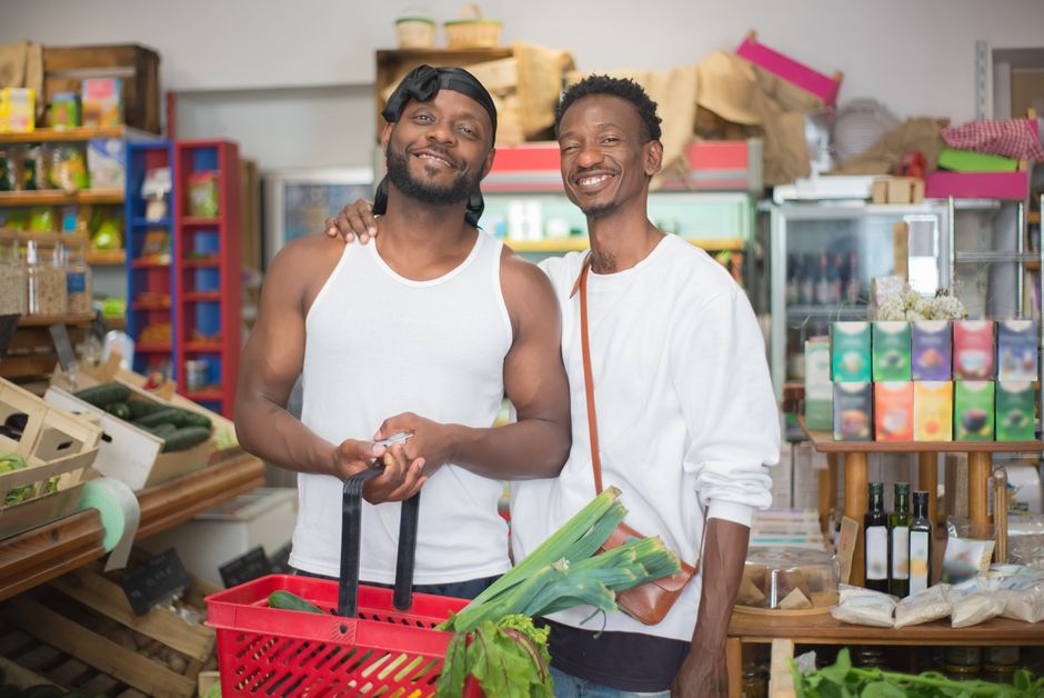 A joyful couple shopping for groceries, holding a basket filled with fresh vegetables. A joyful couple shopping for groceries, holding a basket filled with fresh vegetables.