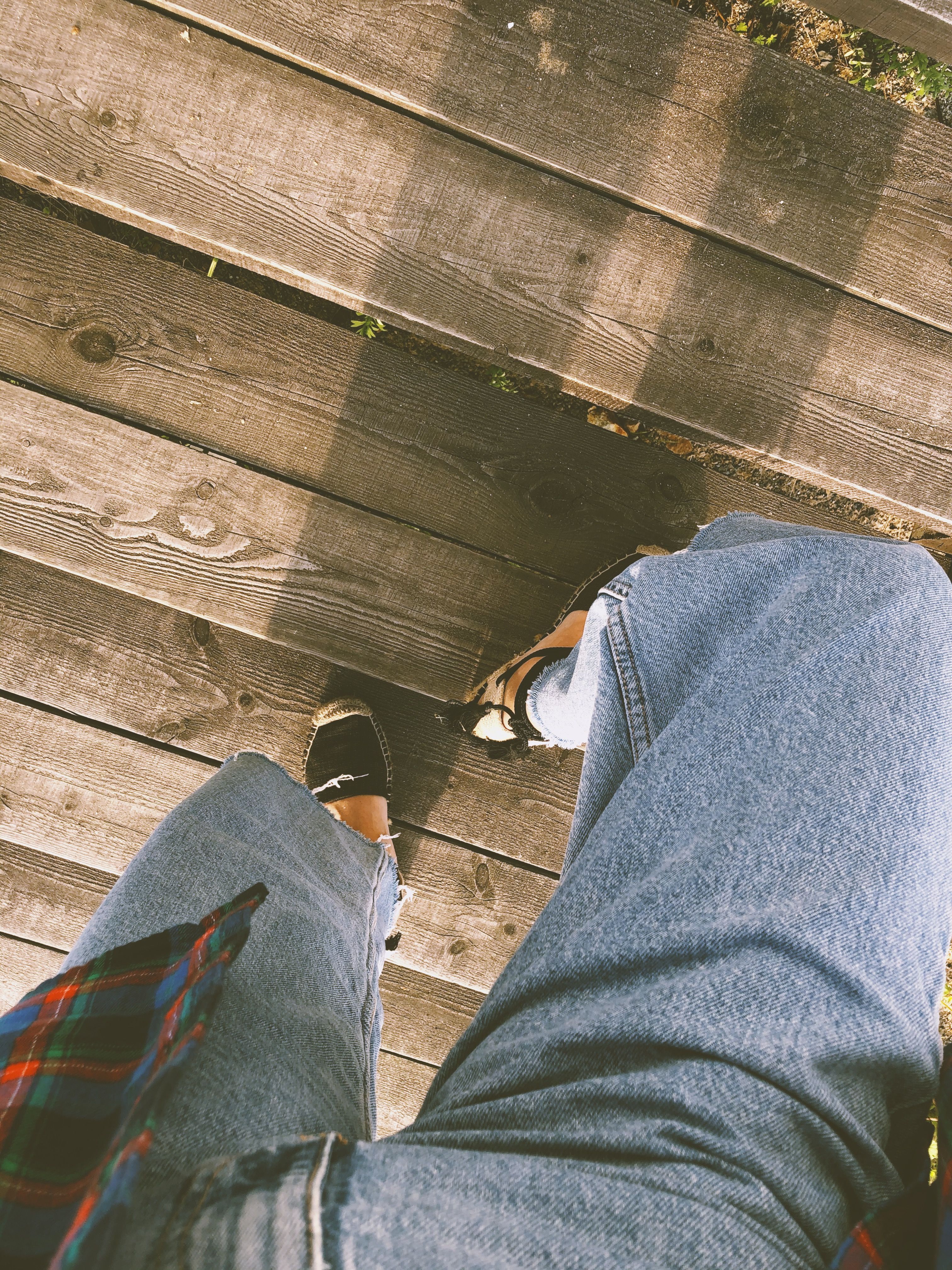 A stylish person walking down wooden stairs, captured from above in Vladivostok, Russia.
