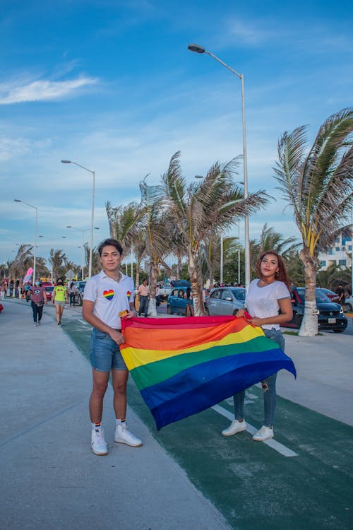 Man and Woman Holding a Rainbow Flag on a Pride Parade