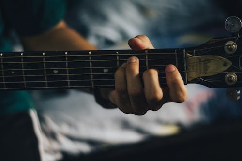 Close-Up Shot of a Person Playing Acoustic Guitar