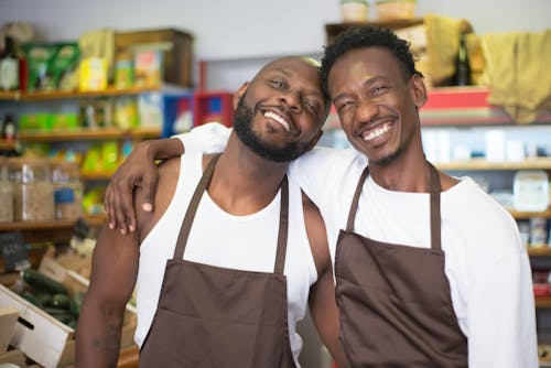 Free Men Smiling Together while in a Grocery Stock Photo