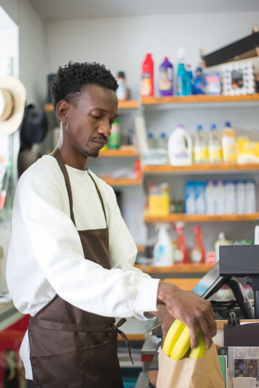 A supermarket employee packs produce as grocers weigh staffing costs against service levels