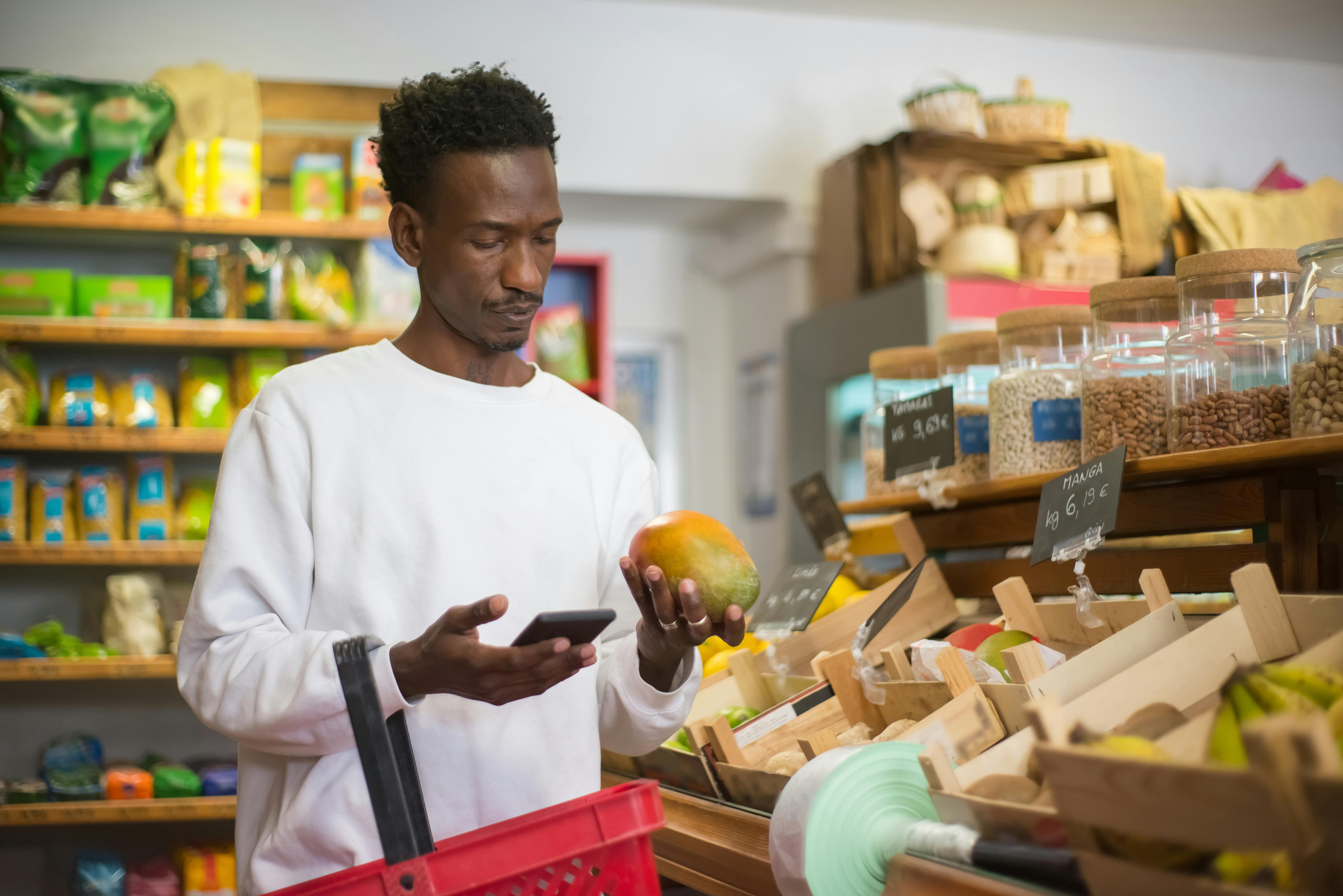 a man looking at a mango fruit