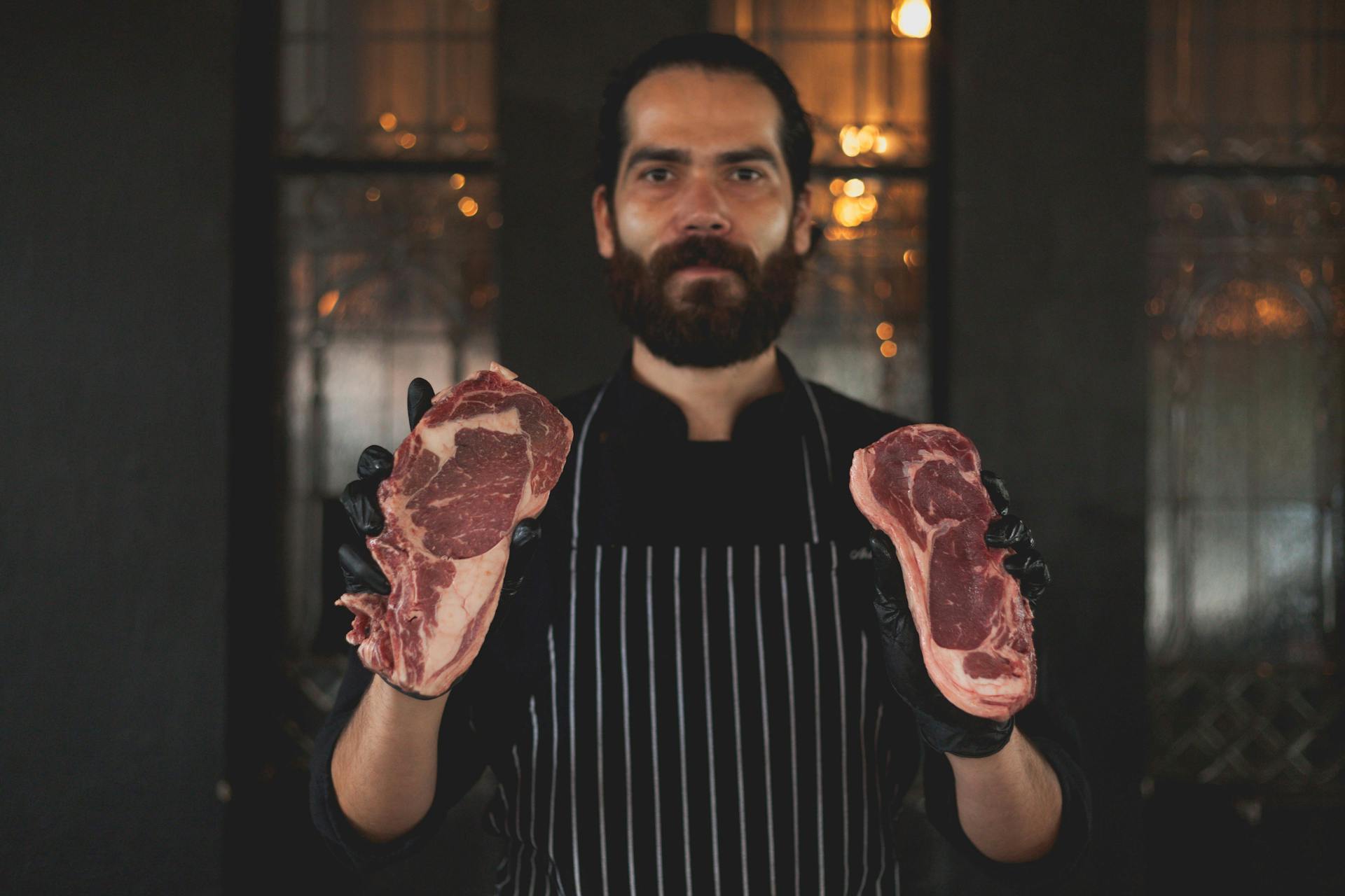 Bearded Man Holding Slices of Raw Meat