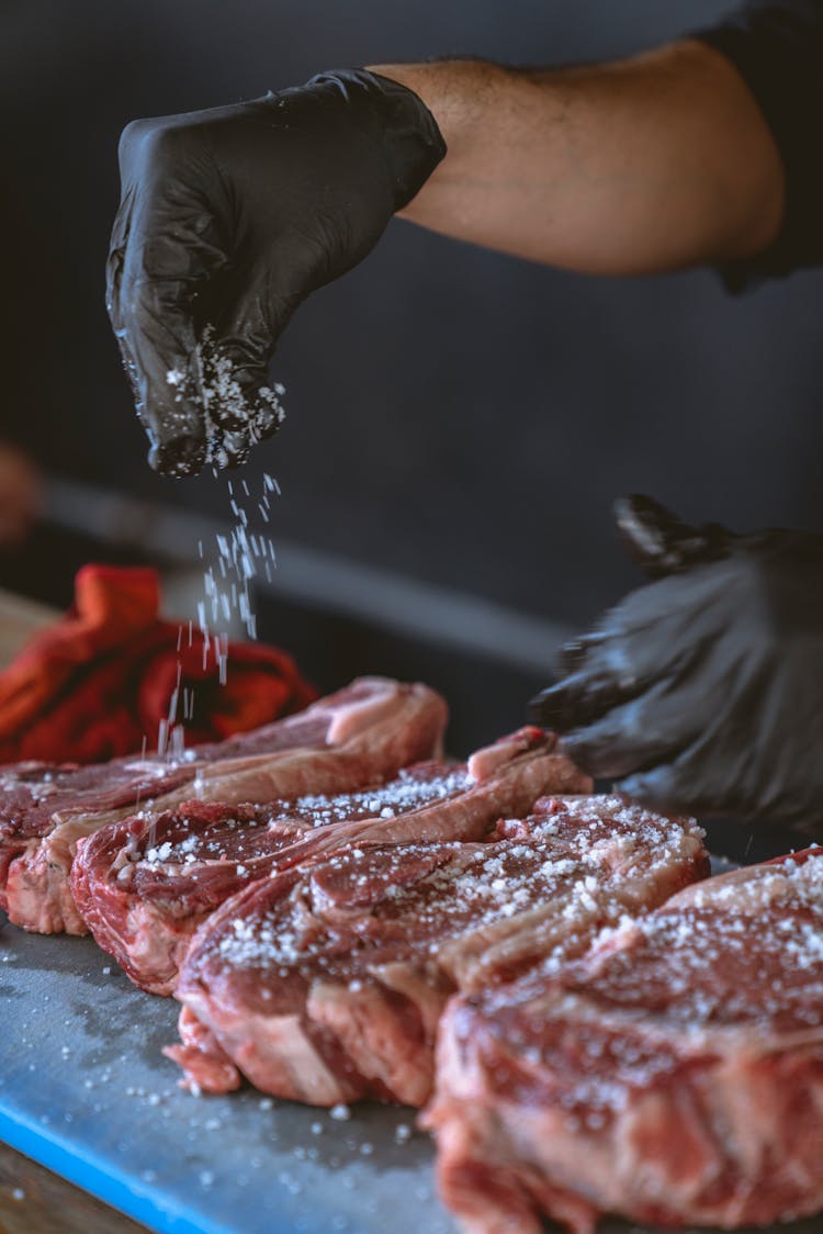 Person Seasoning The Steak