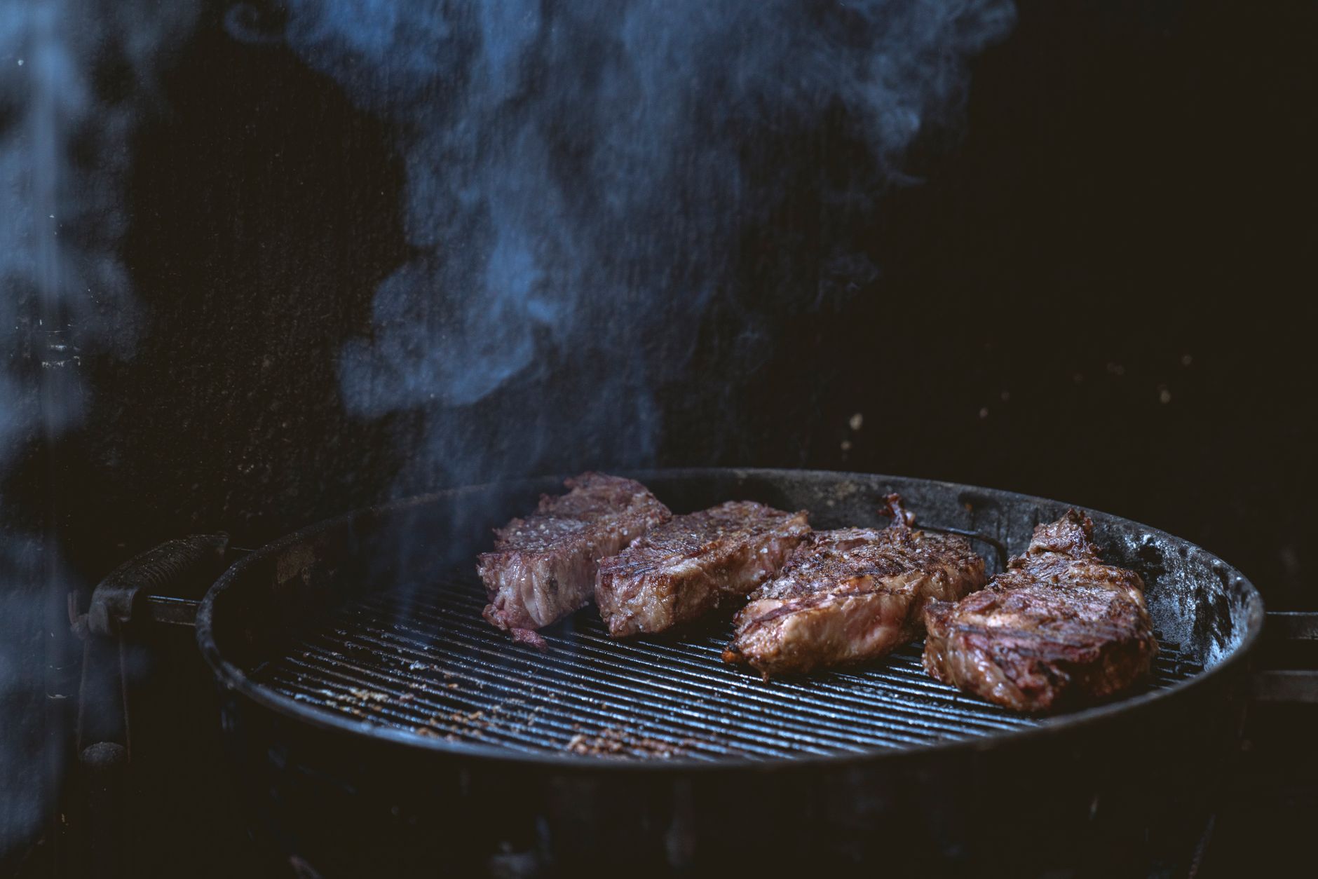 Coulotte steak grilling on a barbecue, sizzling over hot flames