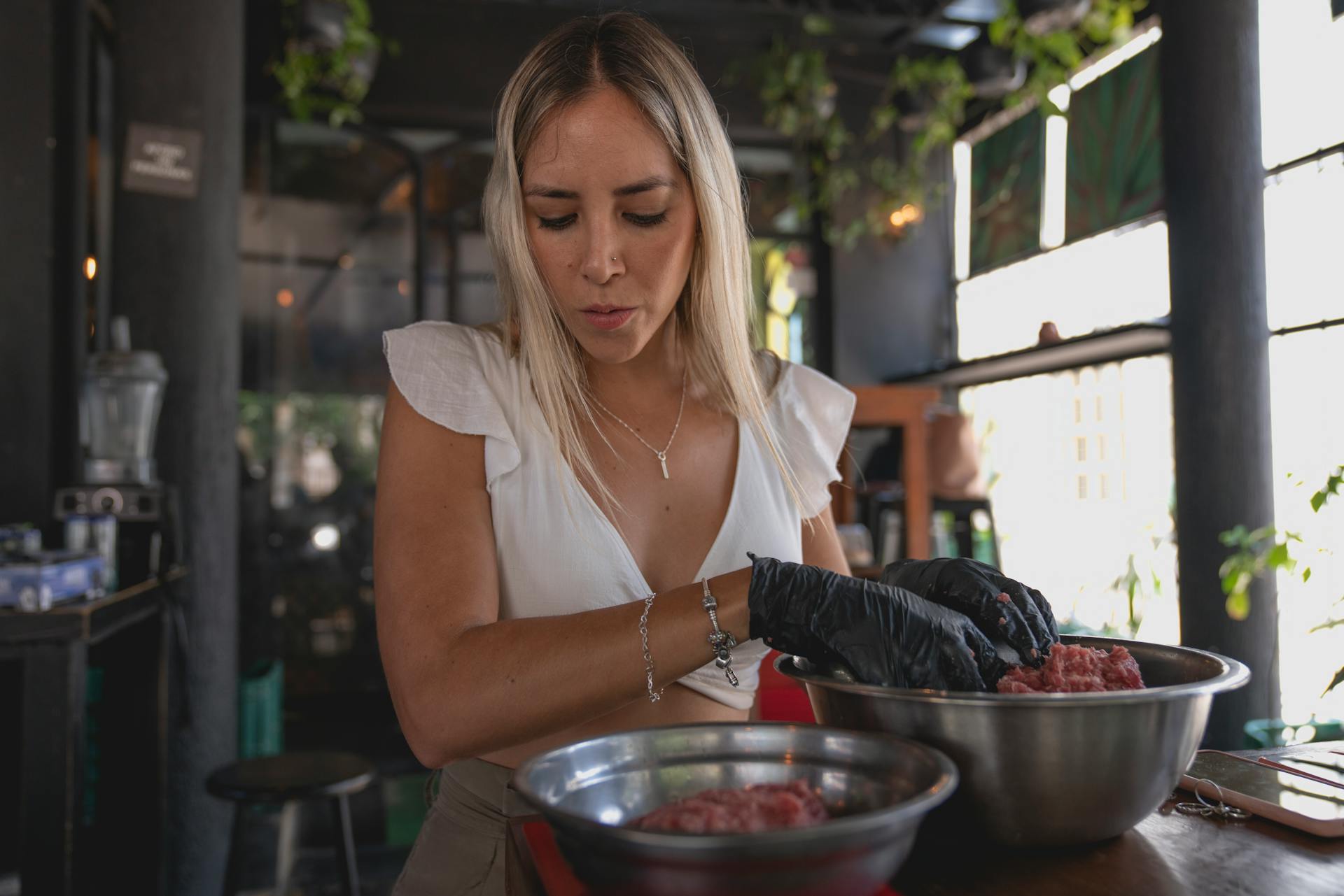 Woman Wearing Gloves Preparing the Meat in a Bowl