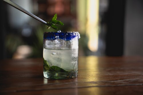 Clear Drinking Glass With Ice and Green Leaves