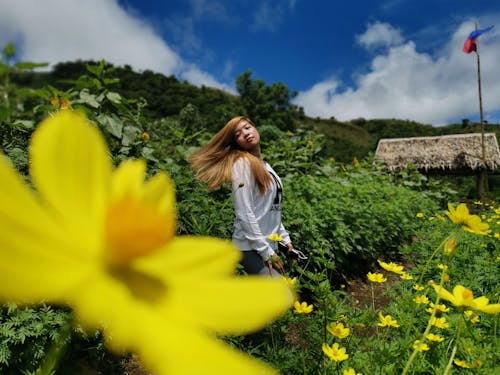 A Young Woman Flipping her Hair in a Garden