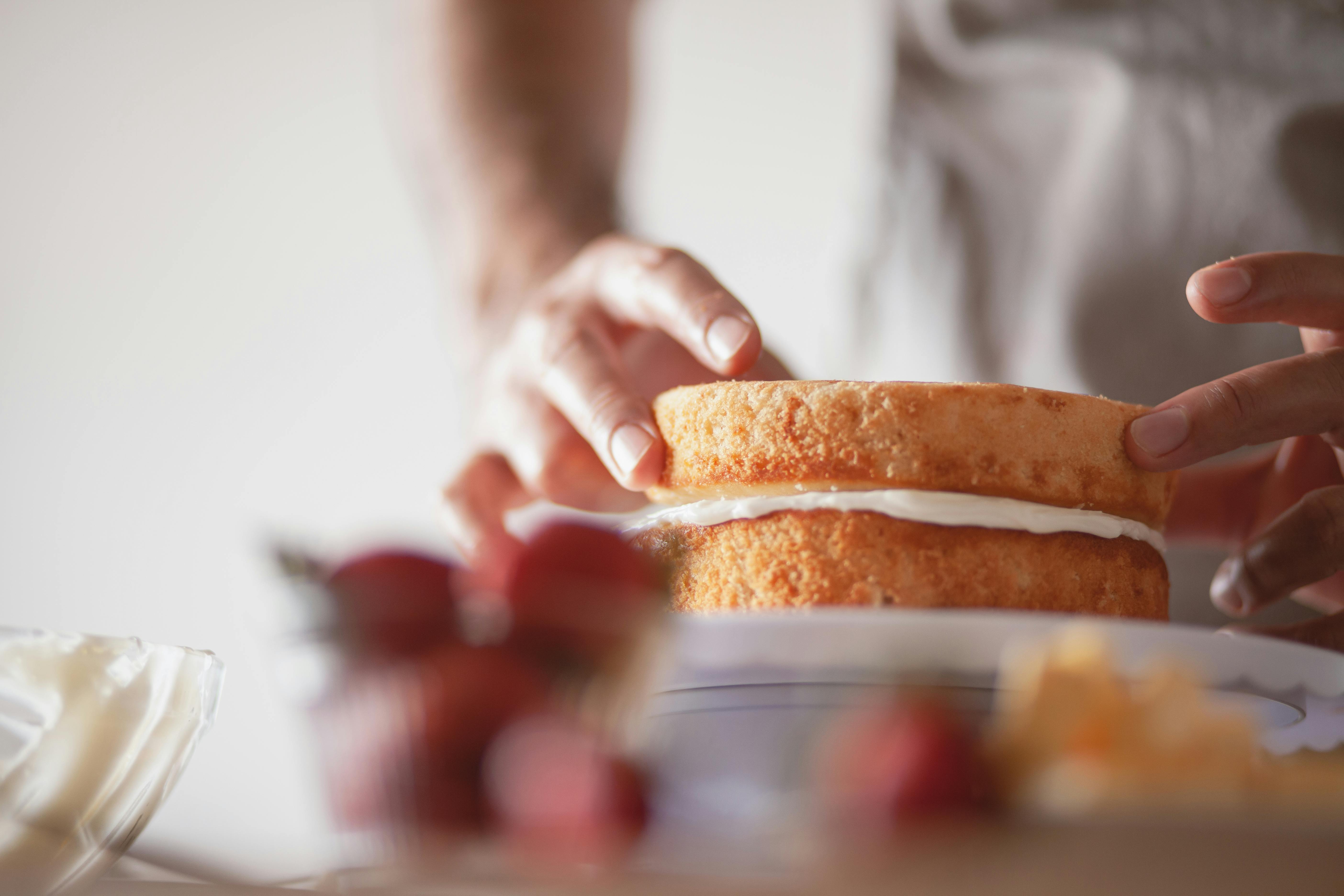 Person decorating a cake