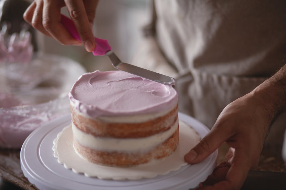 Cook holding a Dutch oven of rustic beef stew in a home kitchen