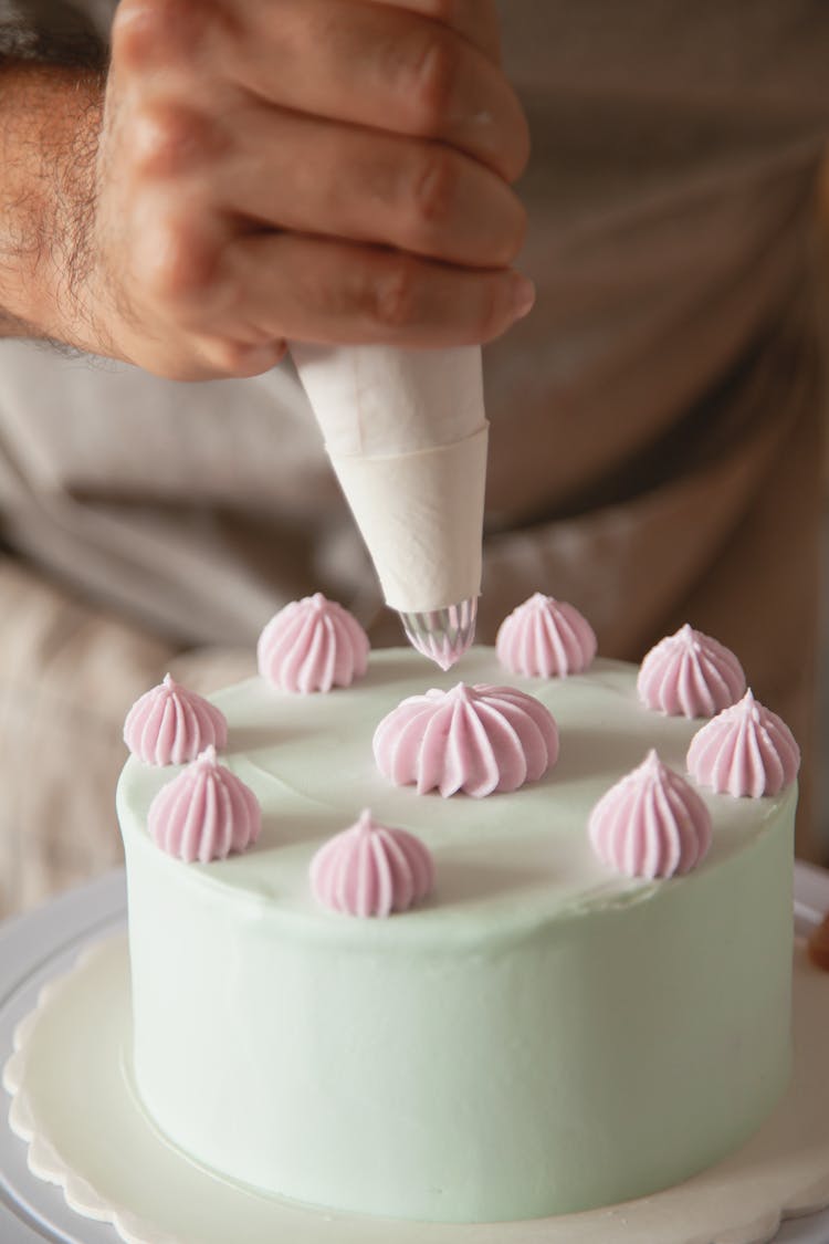 Person Decorating A Cake