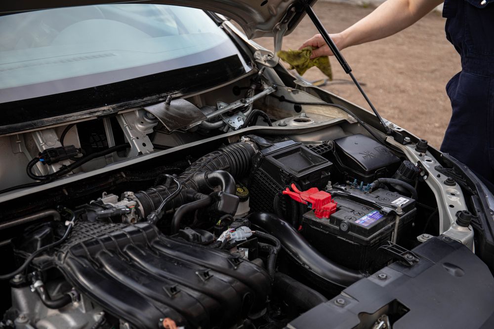 Mechanic inspecting a car engine bay during routine maintenance