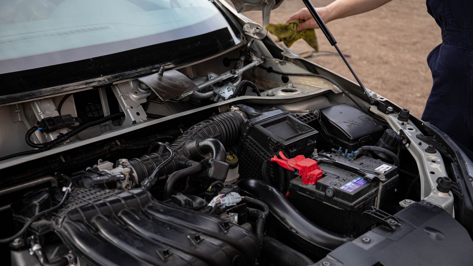 Profissional conferindo o motor e o histórico de manutenção de um carro usado