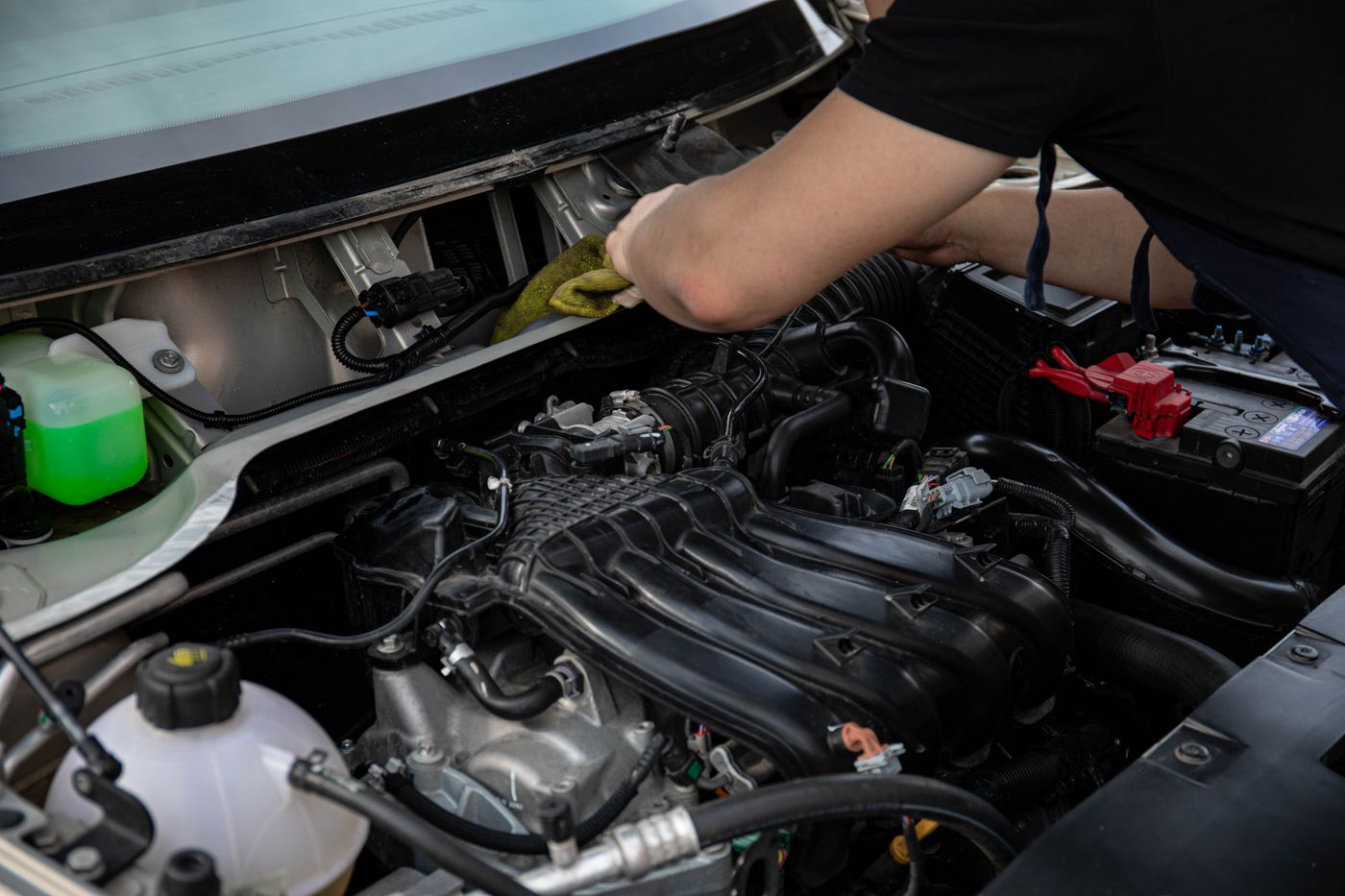 Mechanic's hands working on car engine components
