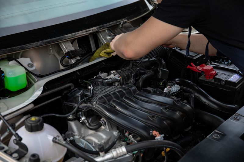 Mechanic working closely on an engine under the hood