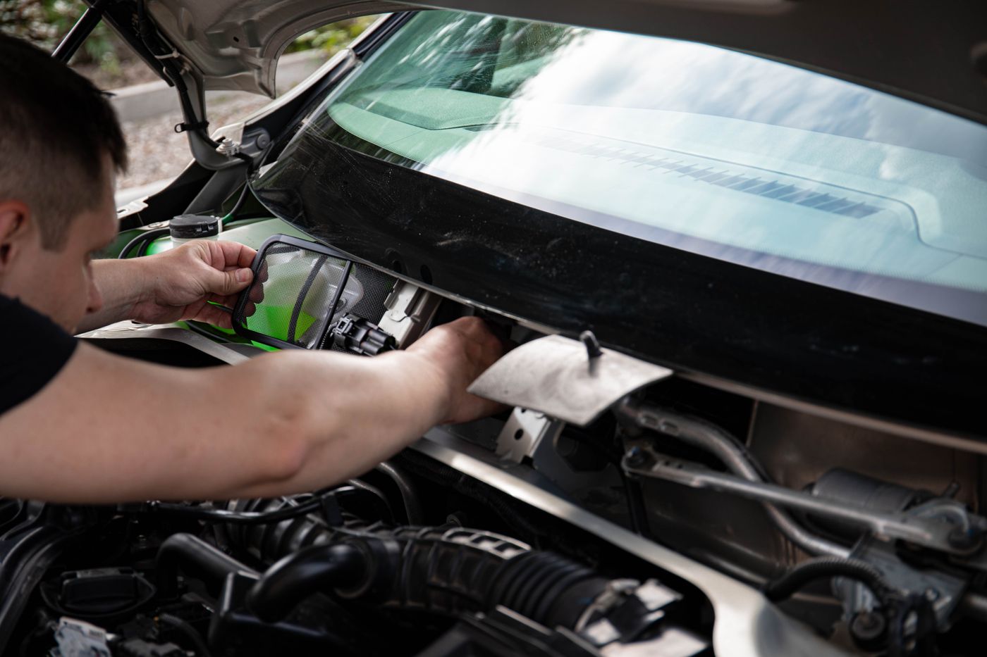 Motorraum und Hände bei einer allgemeinen Reparaturszene.