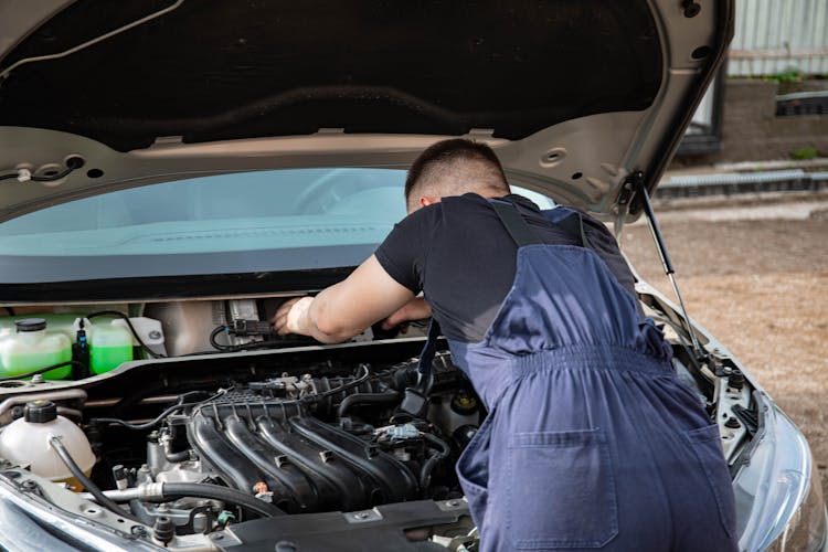 Male Mechanic Fixing A Car Part