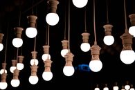 A collection of illuminated hanging bulbs in a dark ambient setting, creating a warm and inviting atmosphere.