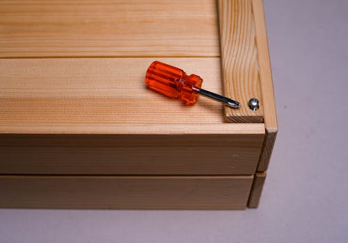 Close-up of a Mini Screwdriver on a Wooden Container 